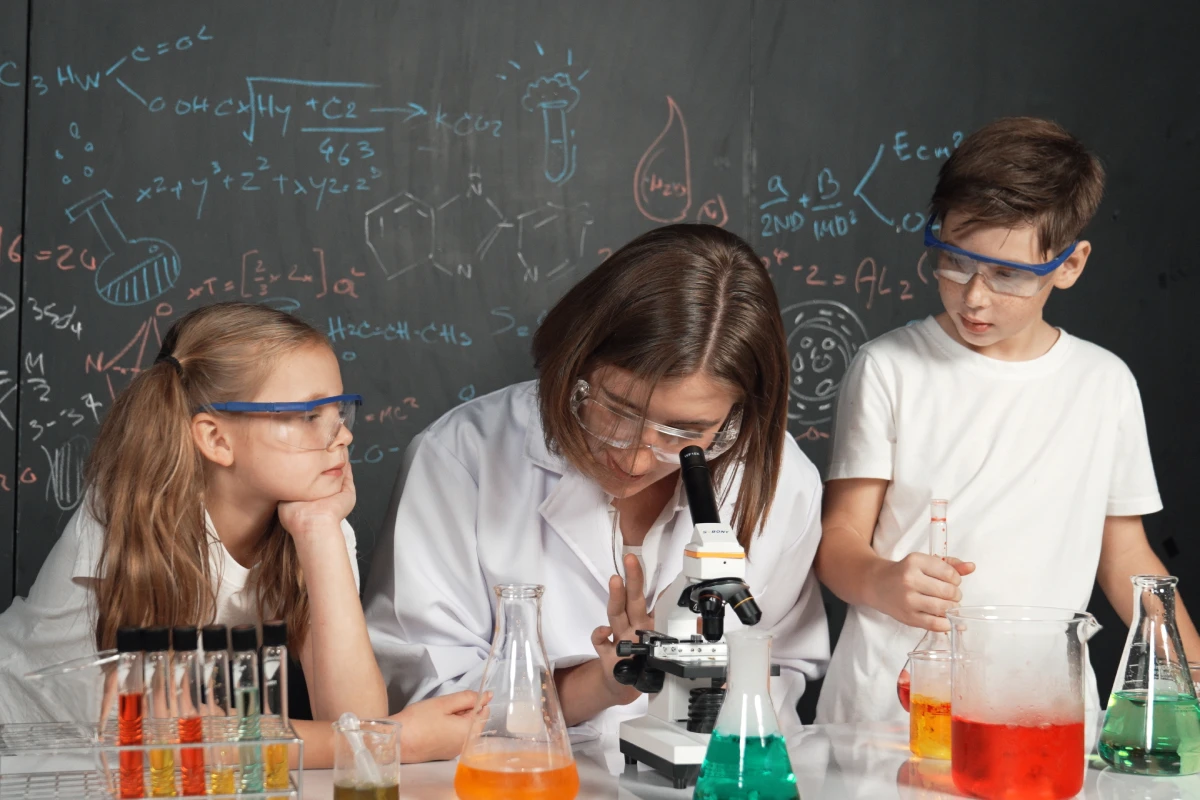 smart-teacher-looking-microscope-while-teacher-giving-advice-eruditionvvv1